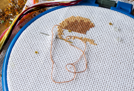 cross stitch,beads on fabric, hand made backgroundの写真素材