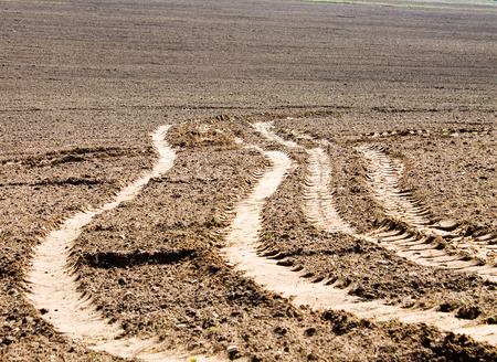 Vehicle tracks and footprints on the sandy ground for background.Traces from the car go to a distance spaceの写真素材