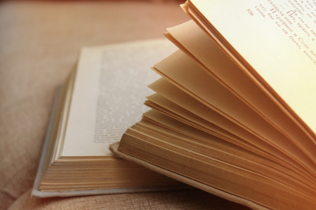 an open book in front of a girl, a girl reading a Russian writer's book War and Peaceの写真素材