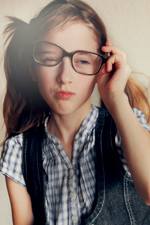 Little kid girl looking happy wearing glasses. Vintage portrait, close upの写真素材