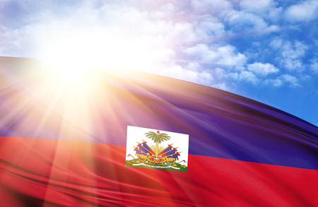 flag of Haiti against the blue sky with sun rays.の写真素材