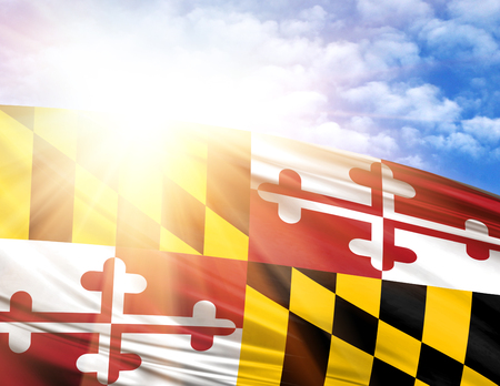 flag of State of Maryland against the blue sky with sun rays.の写真素材