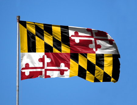 National flag State of Maryland on a flagpole in front of blue sky.