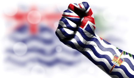 Flag of British Territory in the Indian Ocean drawn on male fist, strength,power,concept of conflict. On a blurred background with a good place for your text.の写真素材