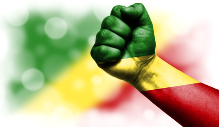Flag of Congo Republic drawn on male fist, strength,power,concept of conflict. On a blurred background with a good place for your text.の写真素材