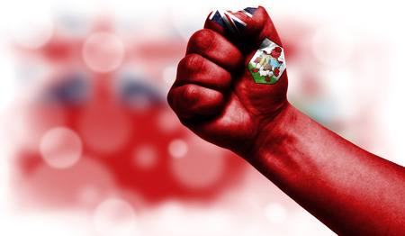 Flag of Bermuda Islands drawn on male fist, strength,power,concept of conflict. On a blurred background with a good place for your text.の写真素材