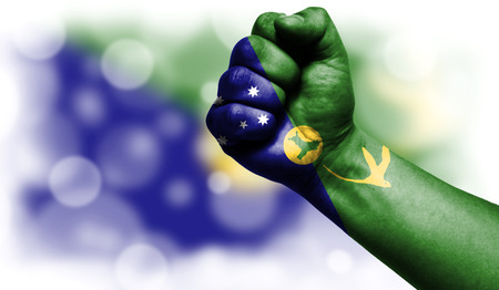 Flag of Christmas Island drawn on male fist, strength,power,concept of conflict. On a blurred background with a good place for your text.の写真素材