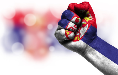 Flag of Serbia painted on male fist, strength,power,concept of conflict. On a blurred background with a good place for your text.の写真素材