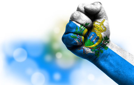 Flag of San marino painted on male fist, strength,power,concept of conflict. On a blurred background with a good place for your text.の写真素材