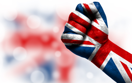 Flag of United Kingdom painted on male fist, strength,power,concept of conflict. On a blurred background with a good place for your text.の写真素材