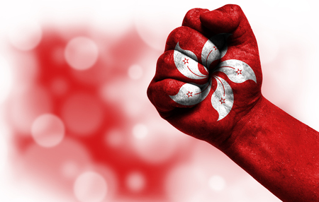 Flag of Hong Kong painted on male fist, strength,power,concept of conflict. On a blurred background with a good place for your text.の写真素材