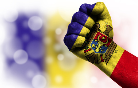 Flag of Moldova painted on male fist, strength,power,concept of conflict. On a blurred background with a good place for your text.の写真素材