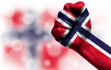Flag of Norway painted on male fist, strength,power,concept of conflict. On a blurred background with a good place for your text.の写真素材
