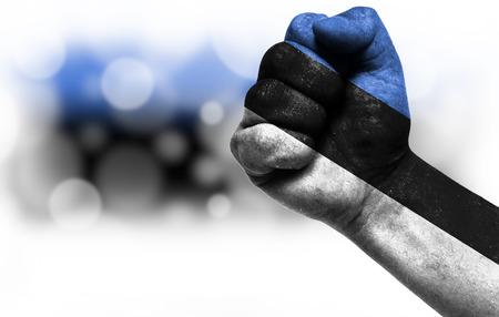 Flag of Estonia painted on male fist, strength,power,concept of conflict. On a blurred background with a good place for your text.の写真素材