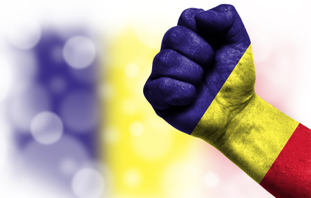 Flag of Romania painted on male fist, strength,power,concept of conflict. On a blurred background with a good place for your text.の写真素材