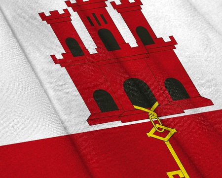 Realistic flag of Gibraltar on the wavy surface of fabric. This flag can be used in designの写真素材