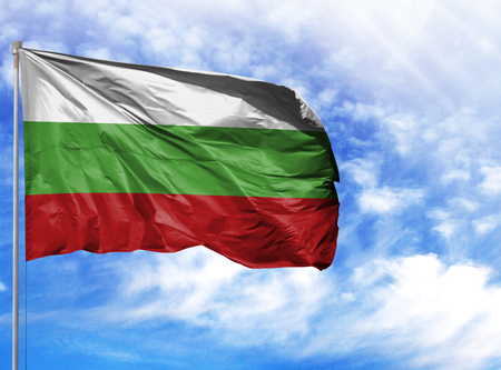 National flag of Bulgaria on a flagpole in front of blue sky.の写真素材