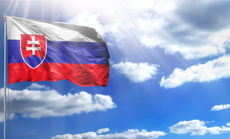 Flag of Slovakia on a flagpole against a blue sky, with a good place for your text.の写真素材