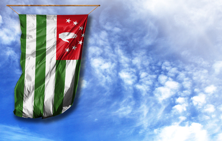 Flag of Abkhazia. Vertical flag, against blue sky with place for your textの写真素材