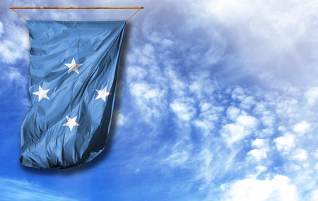 Flag of Micronesia. Vertical flag, against blue sky with place for your textの写真素材