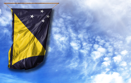 Flag of Tokelau. Vertical flag, against blue sky with place for your textの写真素材