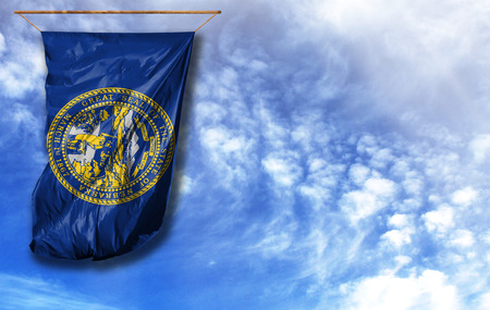 Flag State of Nebraska. Vertical flag, against blue sky with place for your textの写真素材