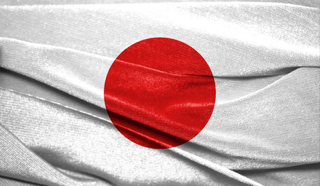 Realistic flag of Japan on the wavy surface of fabric. Perfect for background or texture purposes.の写真素材