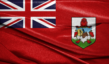 Realistic flag of Bermuda Islands on the wavy surface of fabric. Perfect for background or texture purposes.の写真素材