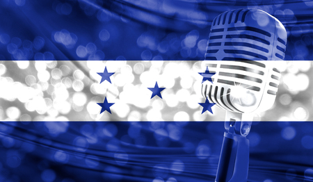 Microphone on a background of a blurry Honduras flag close-upの写真素材