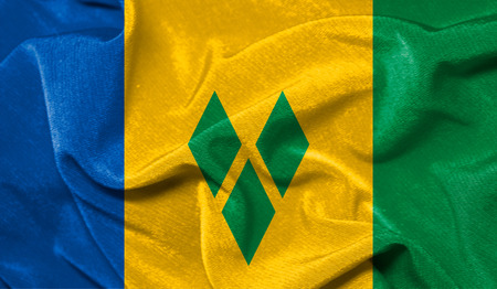 Realistic flag of Saint Vincent and the Grenadines on the wavy surface of fabricの写真素材