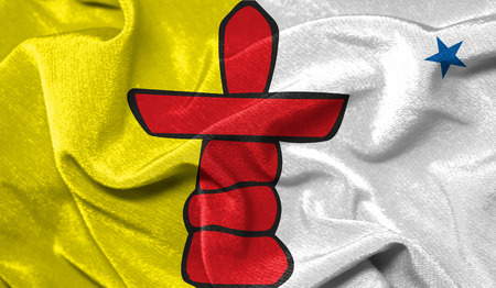 Realistic flag of Nunavut on the wavy surface of fabricの写真素材