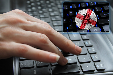 Hand of the girl on the keyboard close up with the concept of digital technology on the purchase and sale of crypto currency bitcoin with a flag of England. The concept of network, communication, technology.の写真素材