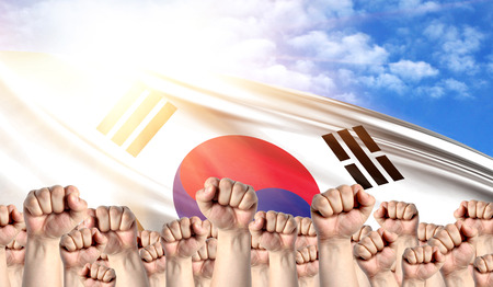Labor Day concept with fists of men against the background of the flag of South Koreaの写真素材
