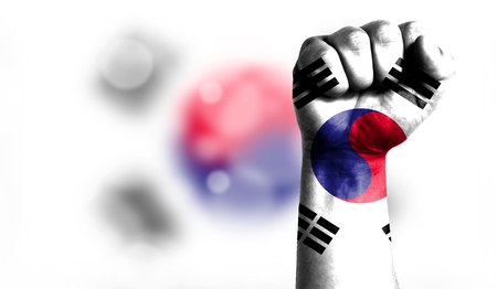 Flag of South Korea painted on male fist, strength,power,concept of conflict. On a blurred background with a good place for your text.の写真素材