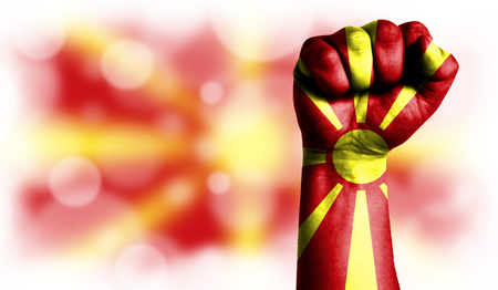 Flag of Macedonia painted on male fist, strength,power,concept of conflict. On a blurred background with a good place for your text.の写真素材