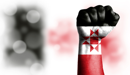 Flag of Udmurtia painted on male fist, strength,power,concept of conflict. On a blurred background with a good place for your text.の写真素材