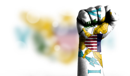 Flag of Virgin Islands of the United States painted on male fist, strength,power,concept of conflict. On a blurred background with a good place for your text.の写真素材