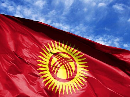 waving flag of Kyrgyzstan close up against blue sky
