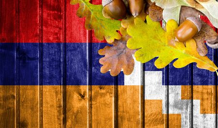 Nagorno Karabakh Republic flag on autumn wooden background with leaves and good place for your text.の写真素材