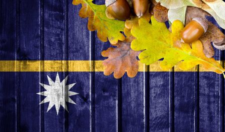 Nauru flag on autumn wooden background with leaves and good place for your text.の写真素材