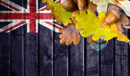 Saint Helena flag on autumn wooden background with leaves and good place for your text.の写真素材