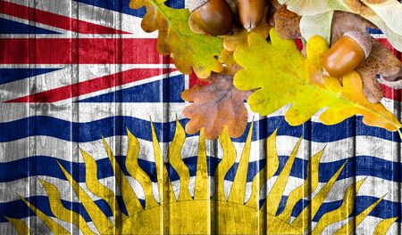 British Columbia flag on autumn wooden background with leaves and good place for your text.の写真素材
