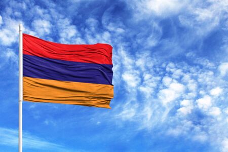 National flag of Armenia on a flagpole in front of blue skyの写真素材