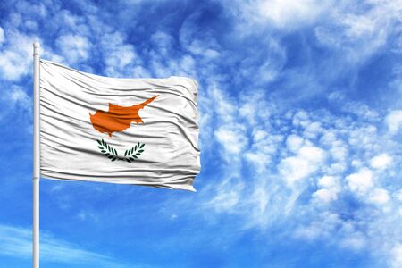 National flag of Cyprus on a flagpole in front of blue skyの写真素材
