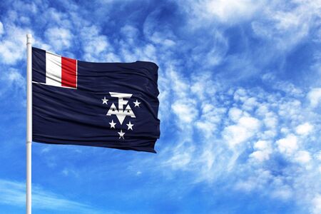 National flag of French Southern and Antarctic Lands on a flagpole in front of blue skyの写真素材