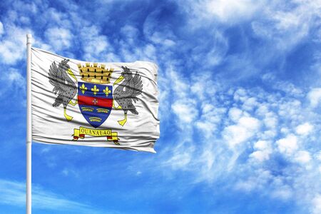 National flag of Saint Barthelemy on a flagpole in front of blue skyの写真素材
