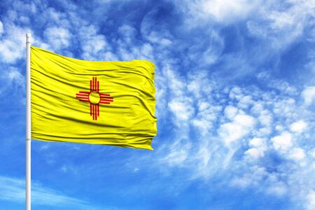 National flag State of New Mexico on a flagpole in front of blue skyの写真素材