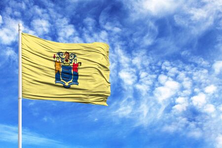 National flag State of New Jersey on a flagpole in front of blue skyの写真素材