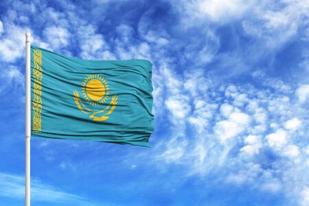 National flag of Kazakhstan on a flagpole in front of blue skyの写真素材