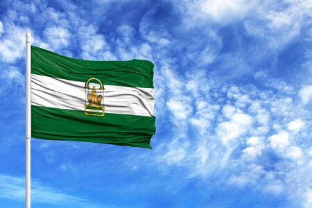 National flag of Andalusia on a flagpole in front of blue skyの写真素材